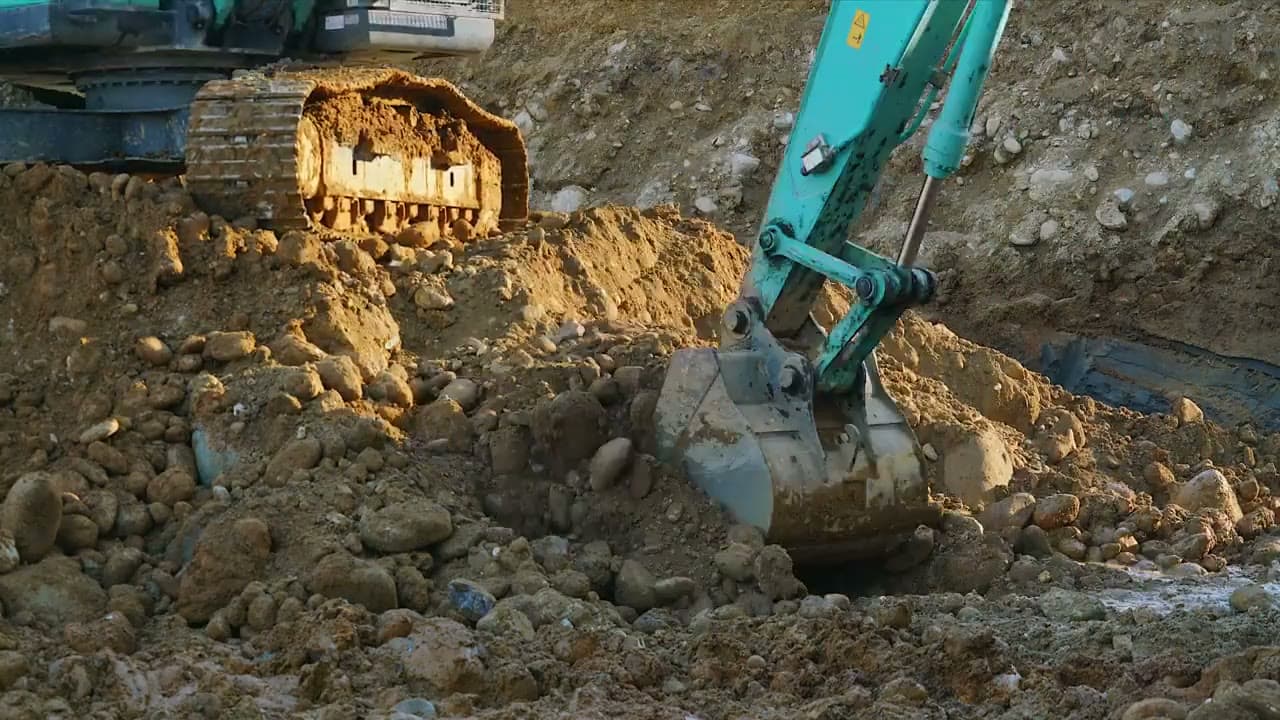 Beispielbild: Nahaufnahme eines Baggers im Erdreich. Kein ausgeführtes Projekt.